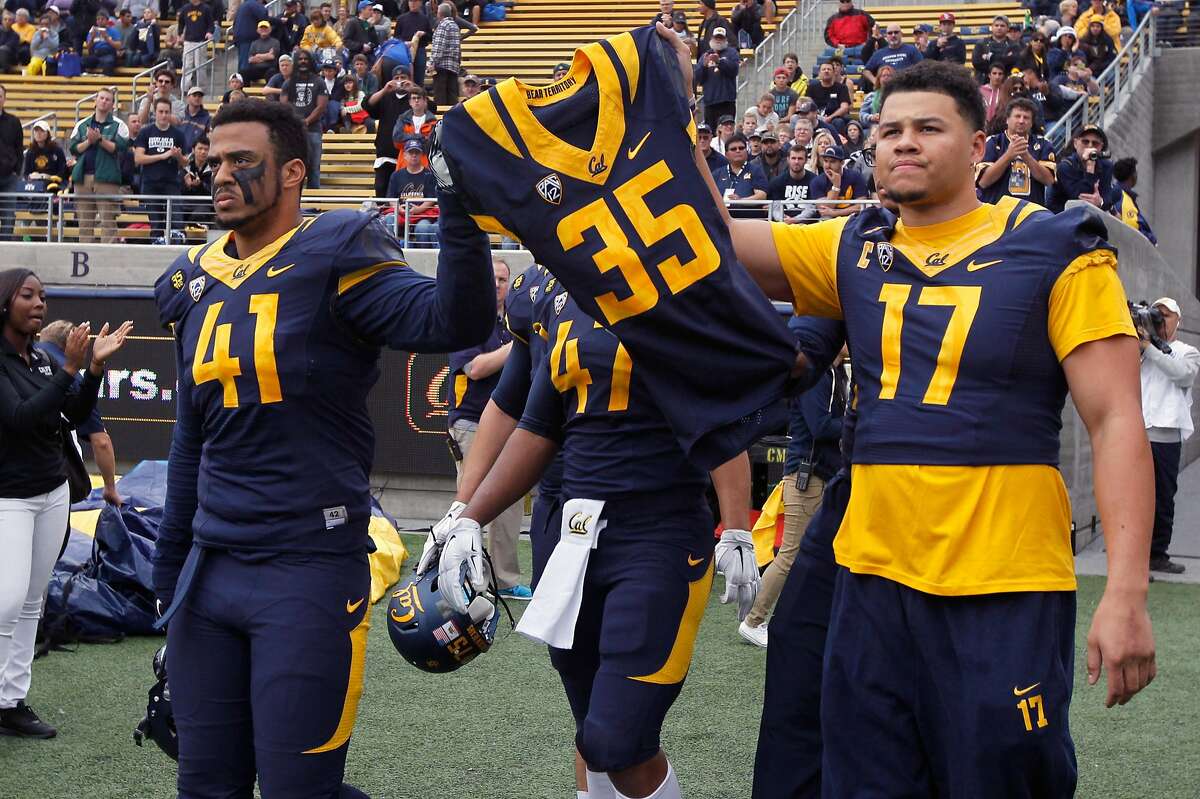 Cal Bears players carry the jersey of Ted Agu, to honor the teammate who died after a preseason training session, before the game against the BYU Cougars at Memorial Stadium in Berkeley, Calif. on Saturday, Nov. 29, 2014.