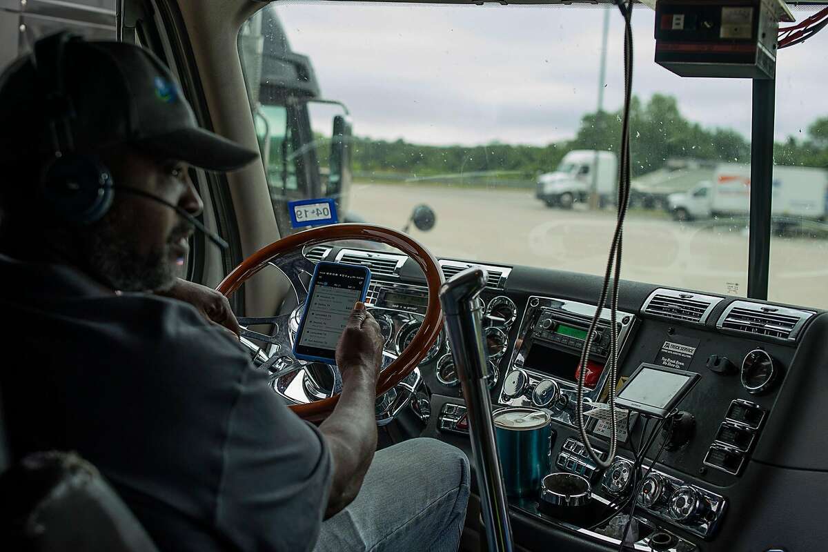 Amir Shah, a truck owner-operator of Traveloko, at the cab of a freight truck look at his Uber Freight app on his mobile phone in Cameron, Texas on Thursday May 24, 2018. Mr. Shah runs most of his business entirely through Uber Freight.