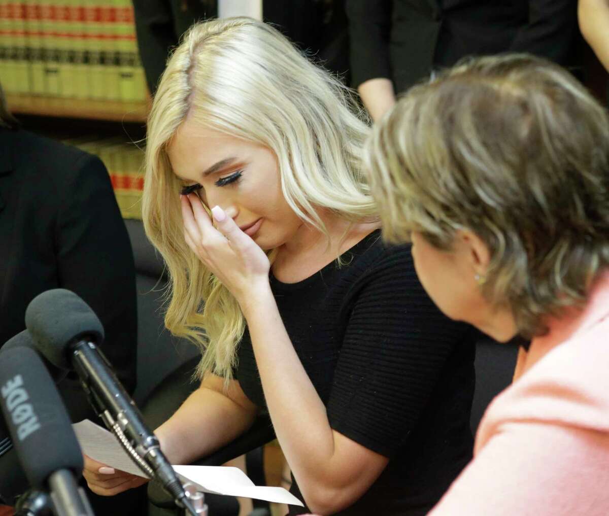Former Houston Texans cheerleader Hannah Turnbow wipes her tears as she speaks sitting beside attorney Gloria Allred during a press conference announcing a lawsuit on behalf of five former Houston Texan NFL cheerleaders shown at the law offices of Kimberley Spurlock, 17280 West Lake Houston Parkway, in Humble, Friday, June 1, 2018.