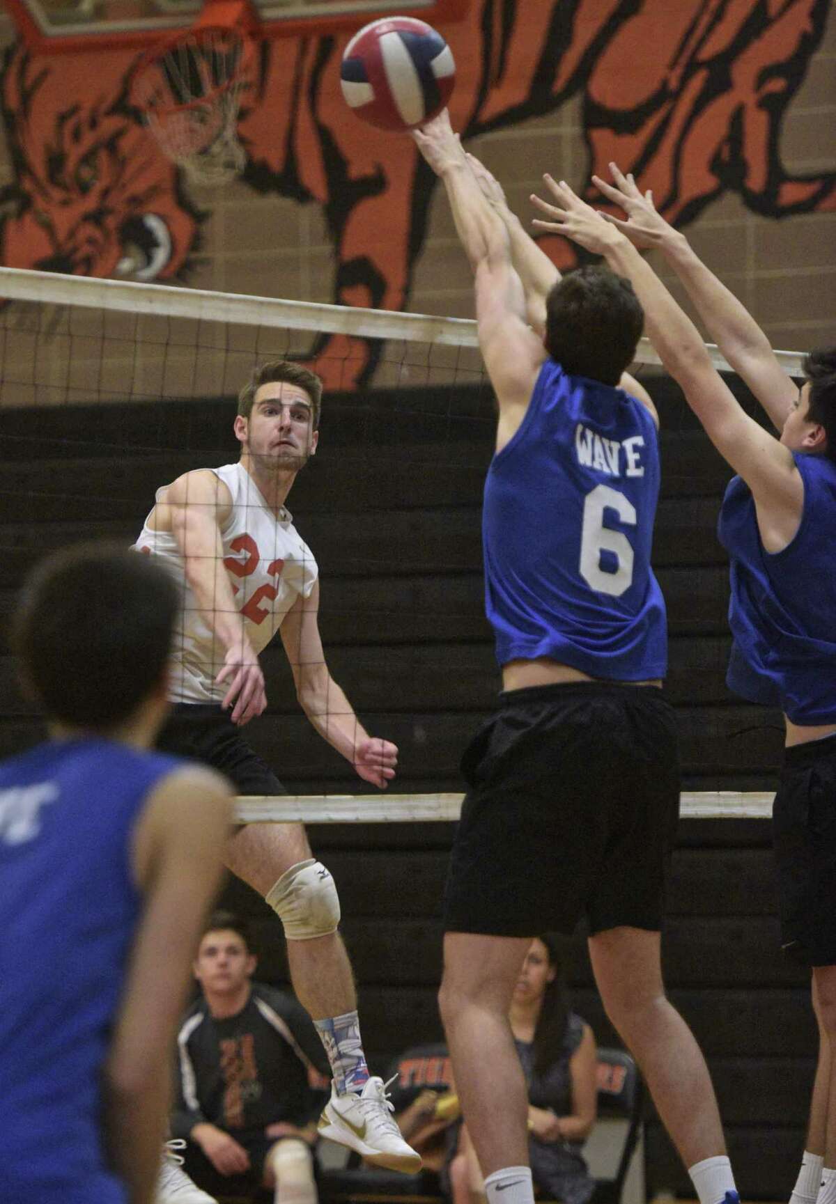 Ridgefield's Christian DeViro (22) spikes the ball past Darien's Jackson Roberson (6) and Nik Tinaj (18) in the boys Class L volleyball game between Darien and Ridgefield high schools. Friday afternoon, June 1, 2018, at Ridgefield High School, Ridgefield, Conn.