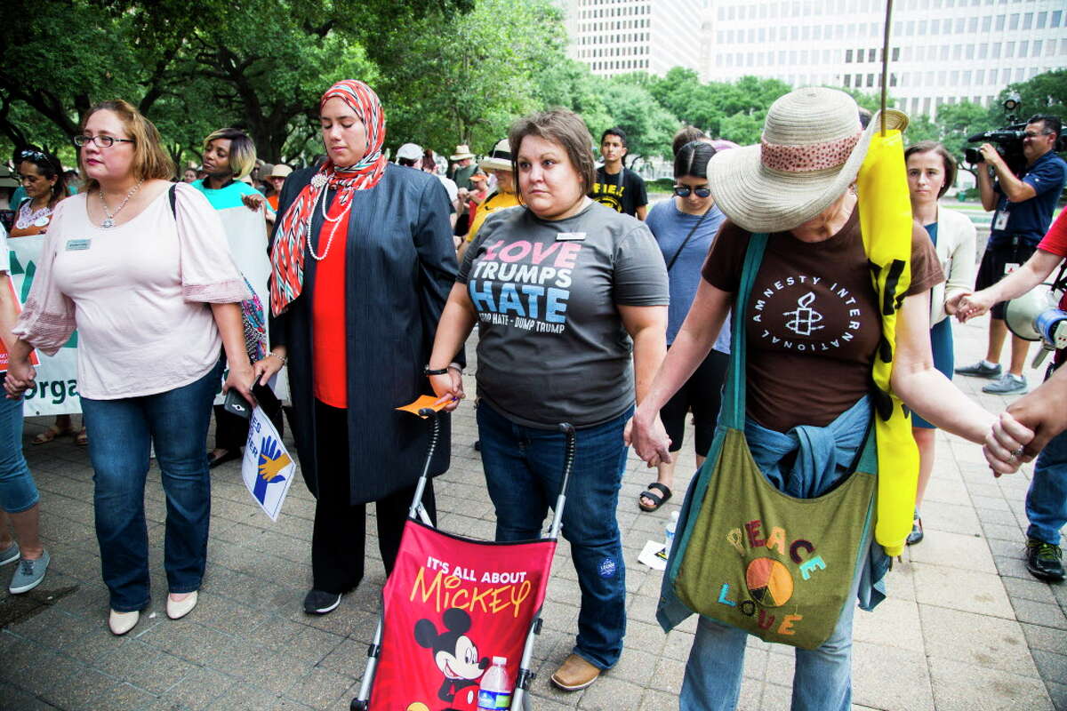 (Left to right) Jennifer Cantu, Dalia Kasseb and Eliz Markowitz join hands in prayer during a protest against the separation of families when they are arrested crossing the border. The rally and protest started at Houston City Hall and ended in front of the U.S. District Courthouse at 515 Rusk St., Friday, June 1, 2018, in Houston.