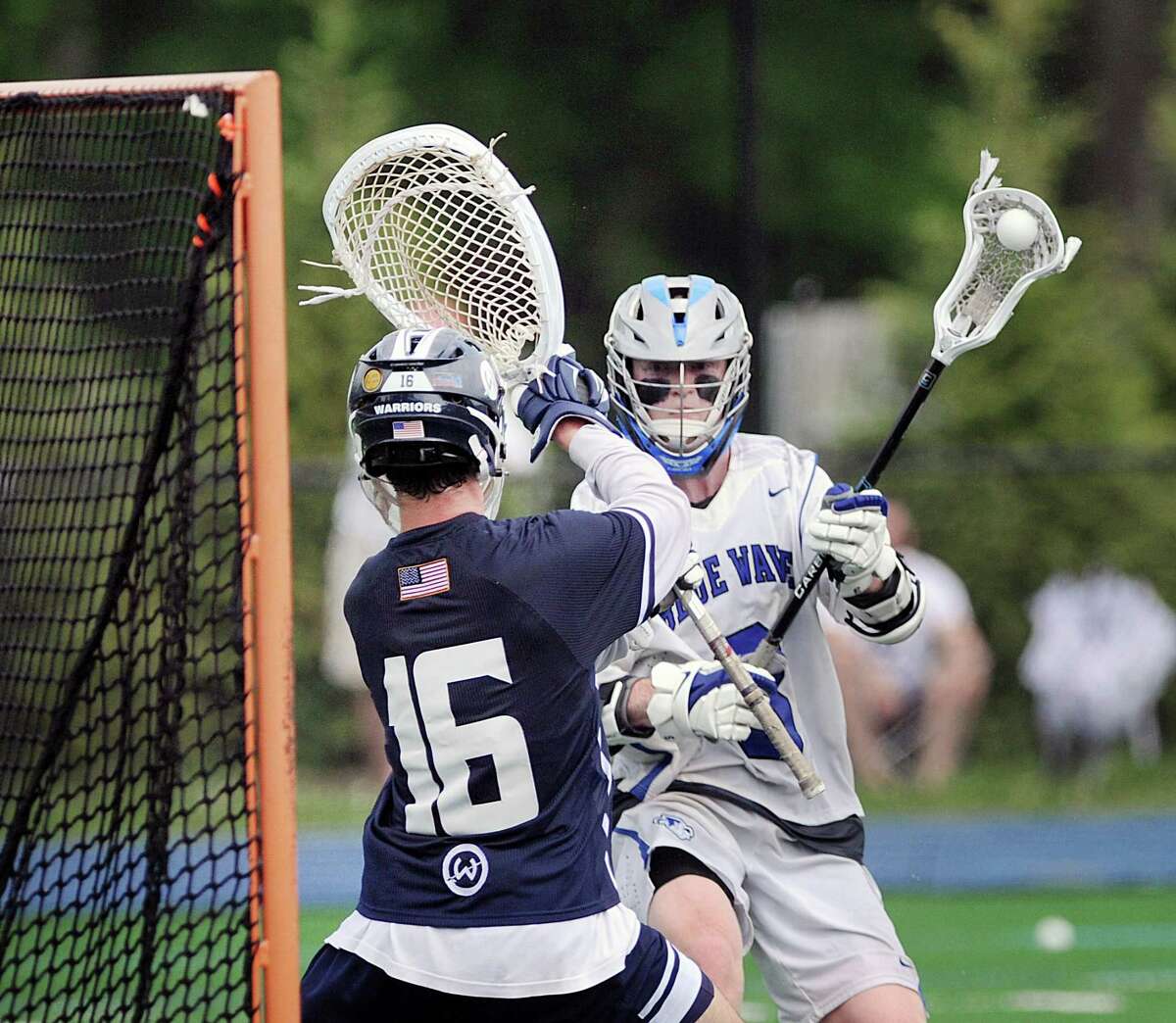 Hudson Pokorny of Darien, right, prepares to shoot as Wilton goalie Andrew Calabrese (#16) defends on a shot that he stopped during the class L boys high school lacrosse quarterfinal match between Dairen High School and Wilton High School at Darien, Conn., Saturday, June 2, 2018. Darien won the match 11-10 over Wilton to advance.