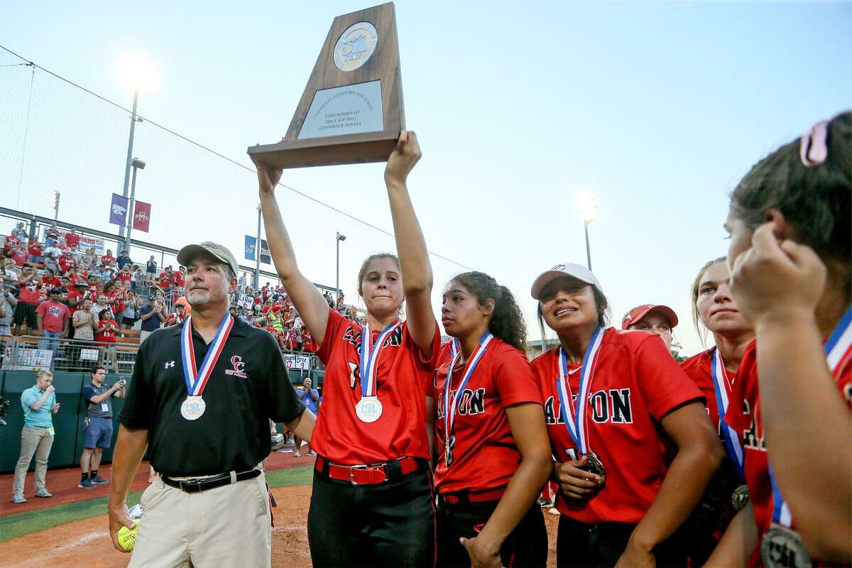 New Braunfels Canyon's Brooke Vestal hoists the runner-up trophy with coach Kevin Randle (left) and the rest of the Cougarettes at the conclusion of their UIL Class 6A state softball final with Humble Atascocita at McCombs Field in Austin on Saturday, June 2, 2018. Atascocita beat Canyon 5-3. MARVIN PFEIFFER/mpfeiffer@express-news.net