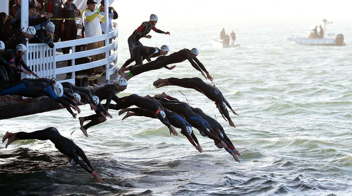 Elite competitors dive off the San Francisco Belle to begin the swimming portion of Escape From Alcatraz Triathlon hosted in San Francisco Sunday June 3, 2018.