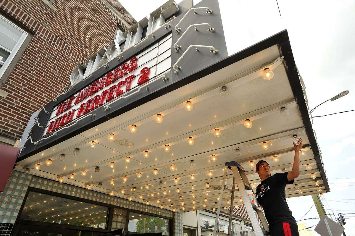 FILE — Concession and maintenance worker Jonathan DaSilva replaces bulbs in the awning of the State Cinema in the Springdale neighborhood of Stamford, Conn., on Sunday, May 17, 2015.