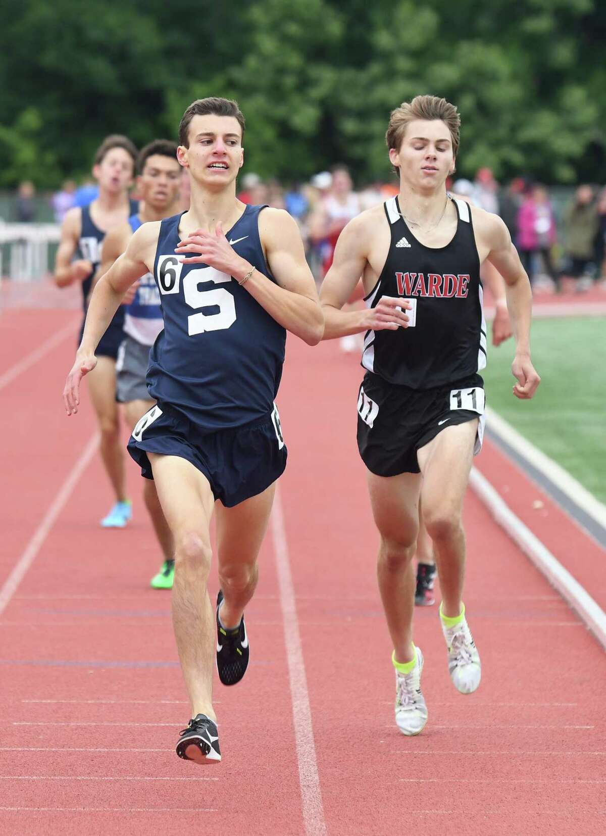 William Landowne, left, of Staples, holds off Fairfield Warde’s Alexander Mocarski in the 1600 at the State Open Track Championships in New Britain on Monday.