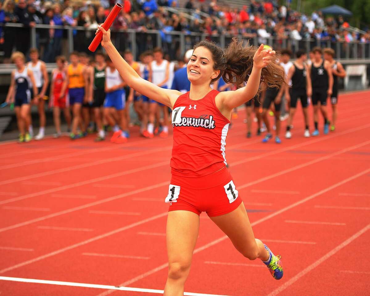 Greenwich’s Emily Philippides raises her arms in victory as she crosses the finish line on the anchor leg of the girls 4x800 meter relay at the CIAC Track & Field Championships in New Britain on Monday.