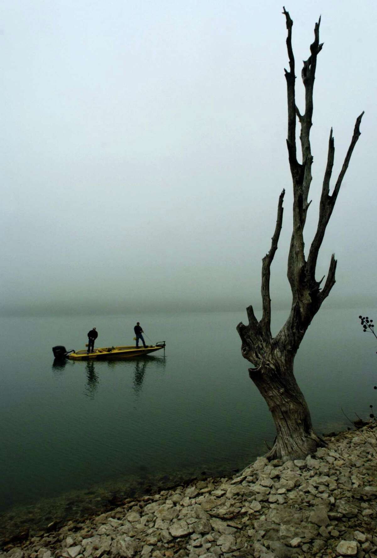 B.J. Gibson, left, and Travis Daugherty, of Jarrell, Texas, fish off their boat on Lake Belton as a recent wave of dense fog hits Central Texas and surrounds them Tuesday, Feb. 21, 2006, in Temple, Texas.