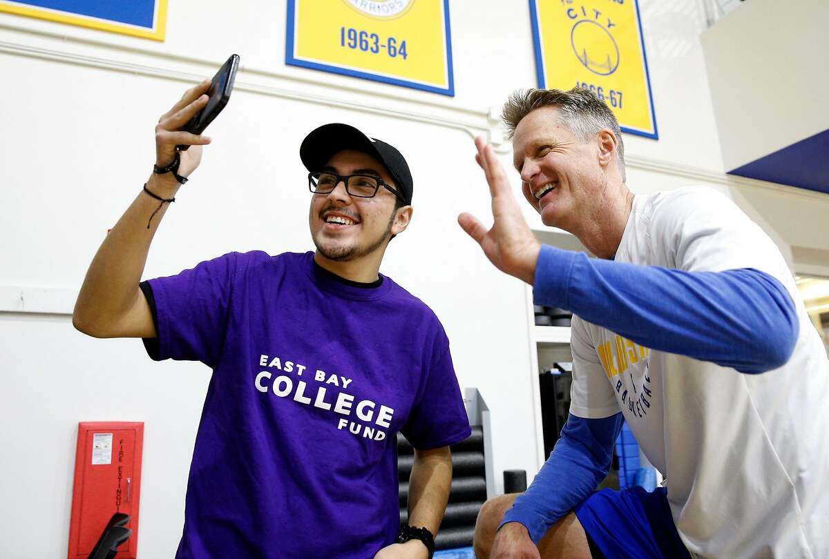 Allan Ahumada, takes a selfie with Warriors' head coach Steve Kerr during a practice session in Oakland, Calif. on Thurs. March 8, 2018. Three students, Johann Romo, Jahlon Andrades and Allan Ahumada are being supported in their educations through the East Bay College Fund, were invited to meet Warriors' head coach Steve Kerr who donates the money he gets from speaking appearances to the program.