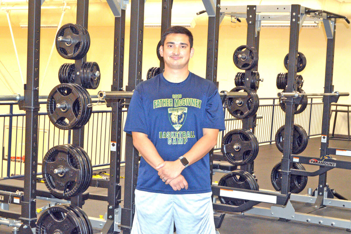 Father McGivney athletic director Jeff Oller poses in the school’s weight room, which opened last summer. FMCHS continues to add to the list of sports that it offers.
