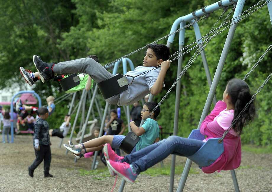 wilson perez, 8, swings high on the playground during recess