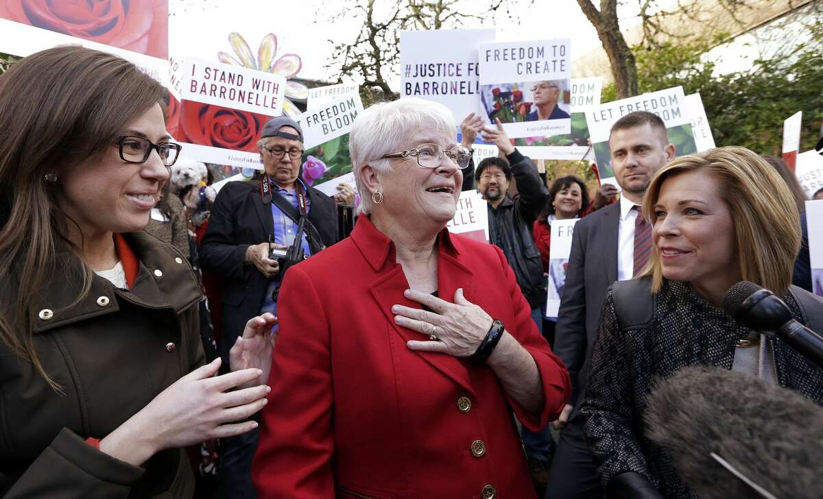 Barronelle Stutzman, center, a Richland, Wash., florist who was fined for denying service to a gay couple in 2013, reacts to being surrounded by supporters after a hearing before Washington's Supreme Court, Tuesday, Nov. 15, 2016, in Bellevue, Wash. Stutzman was sued for refusing to provide services for a same sex-wedding and says she was exercising her First Amendment rights, but justices questioned whether ruling in her favor would mean other businesses could turn away customers based on racial or other grounds. (AP Photo/Elaine Thompson)