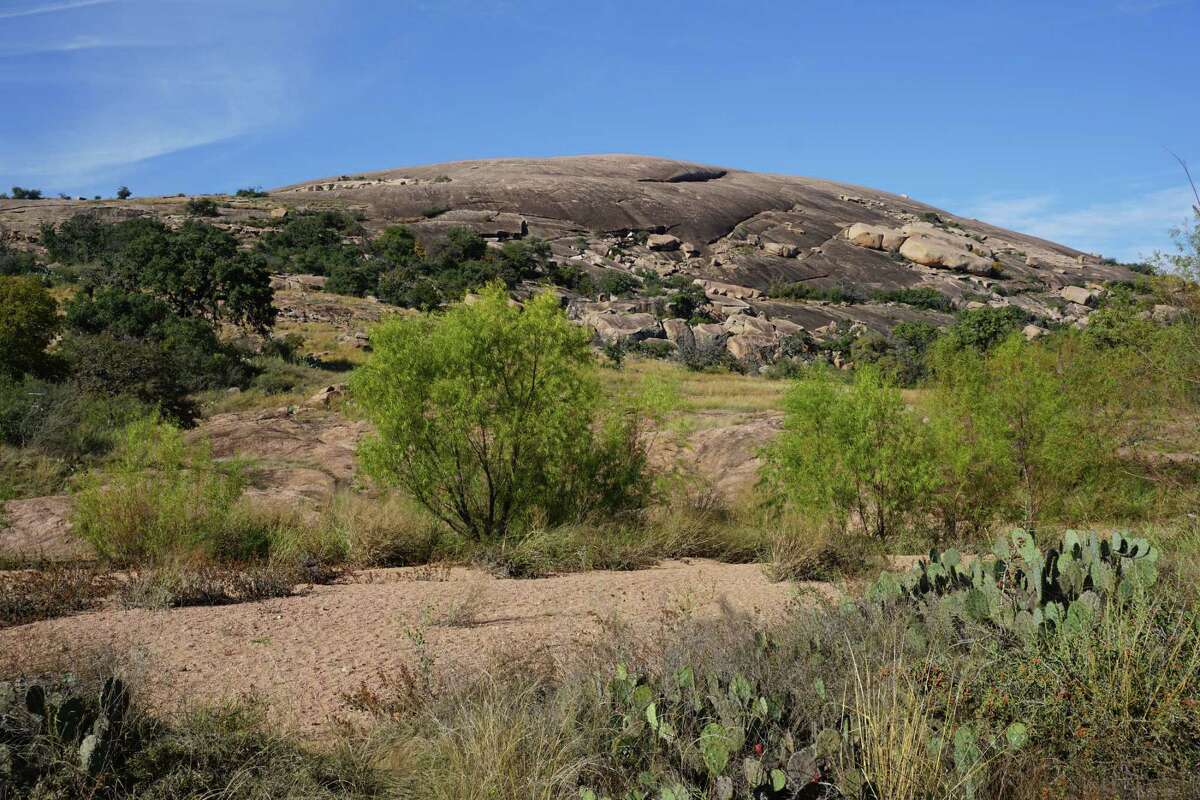 The summit of Enchanted Rock State Natural Area is seen in the distance, a 425-foot change in elevation from where the trail begins. Enchanted Rock is a popular destination for Come Into The Outside hikes.