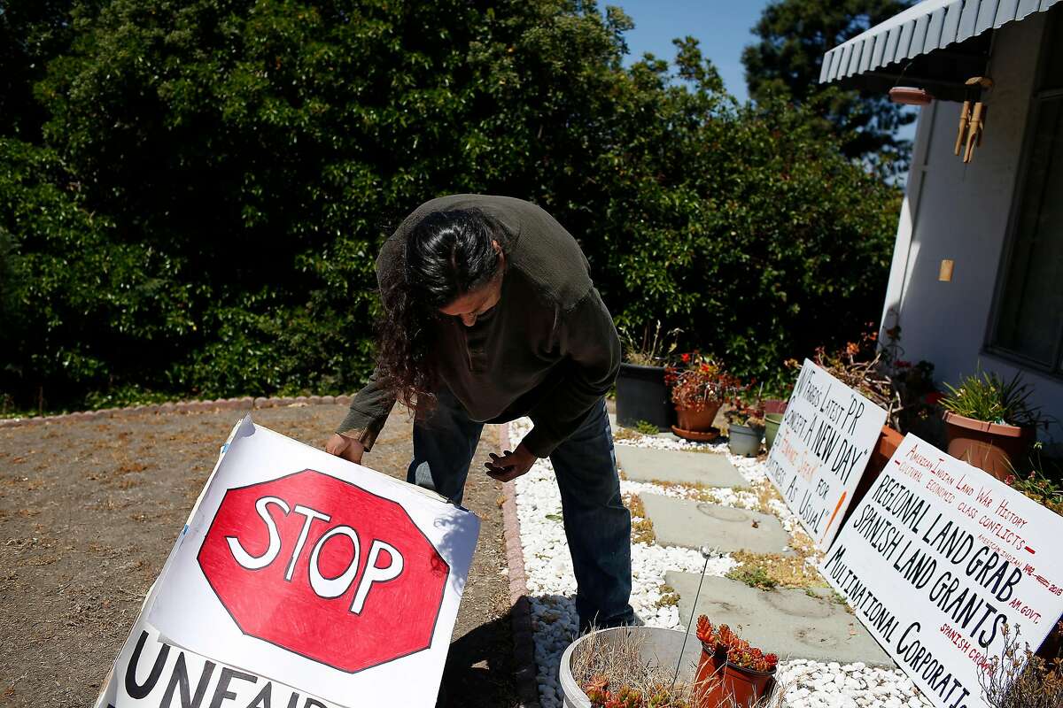 Ricardo Davis, friend of Genny Zentella, gathers signs, used in an earlier action, together which after Zentella was removed from her home earlier in the morning on Tuesday, June 5, 2018 in San Pablo, Calif. A stay of execution had expired at 6 a.m. the day before.