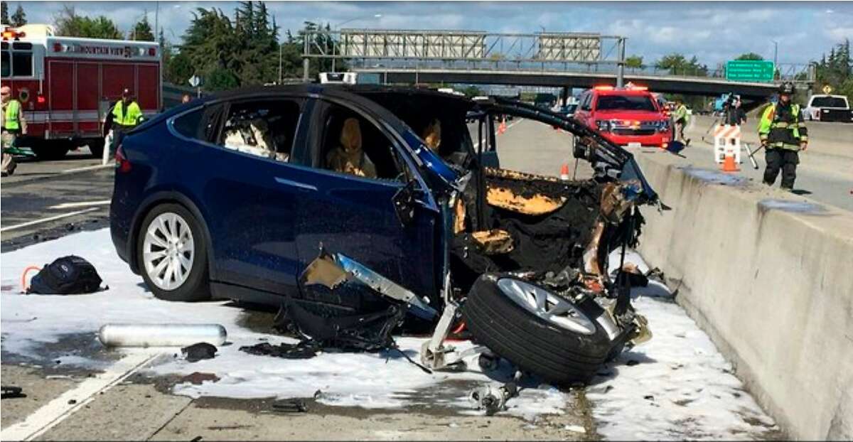 FILE - In this March 23, 2018, file photo provided by KTVU, emergency personnel work at the scene where a Tesla electric SUV crashed into a barrier on U.S. Highway 101 in Mountain View, Calif. Federal safety investigators have booted electric car maker Tesla Inc. from the group investigating a fatal crash in California that involved an SUV operating with the company's Autopilot system. The National Transportation Safety Board said Thursday, April 12, it removed Tesla as a party to the investigation after the company prematurely made information public. (KTVU via AP, File)
