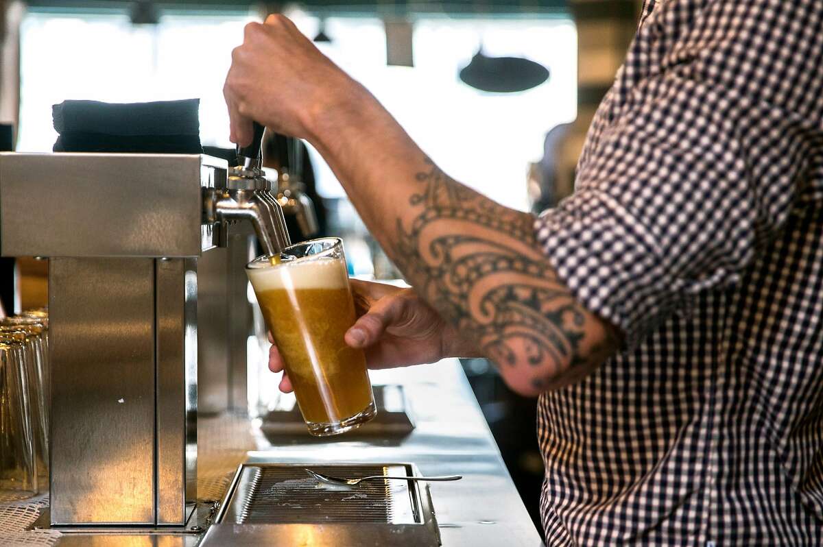 A bartender pours a beer for a patron at the Covo co-working space in San Francisco, Calif. Wednesday, June 6, 2018.