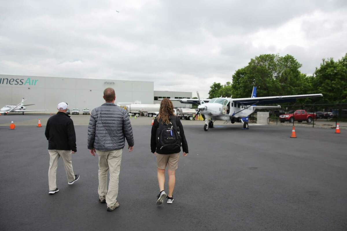 Pilots Mark Beauchamp and Chris Swanson and aerial research photographer Amber Surrency walk to the CoStar Group Cessna Grand Caravan, a slow speed research plane, before taking a flight over downtown Seattle, May, 31, 2018. The crew flies to locations through out the country to gather data, video and images of real estate that will be used to determine trends in the national real estate market.