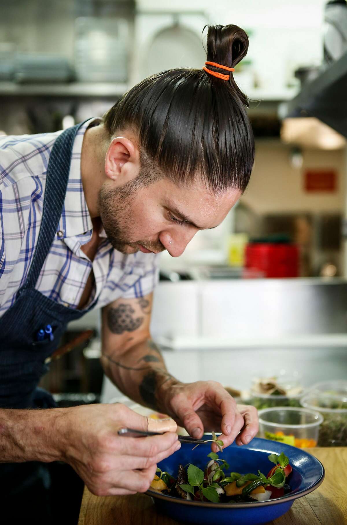 Al's Place chef/owner Aaron London plates a dish of Stone Fruit Curry, Black Lime-cod, Green Bean and Blueberry on Monday, Aug. 17, 2015 in San Francisco, Calif.