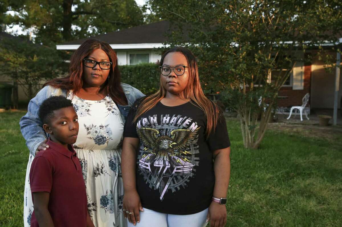Catina Washington, 43, poses for a photograph with her children Jaquavion Jackson, 10, and Jakwannai Washington, 20, in front of their Harvey-flooded house in East Houston on Thursday, May 3, 2018. Washington's ranch-style house took on about four feet of water. The three and Washington's 61-year-old mother, Janice Washington, evacuated their home after they waited more than 20 hours after calling 911 for help.