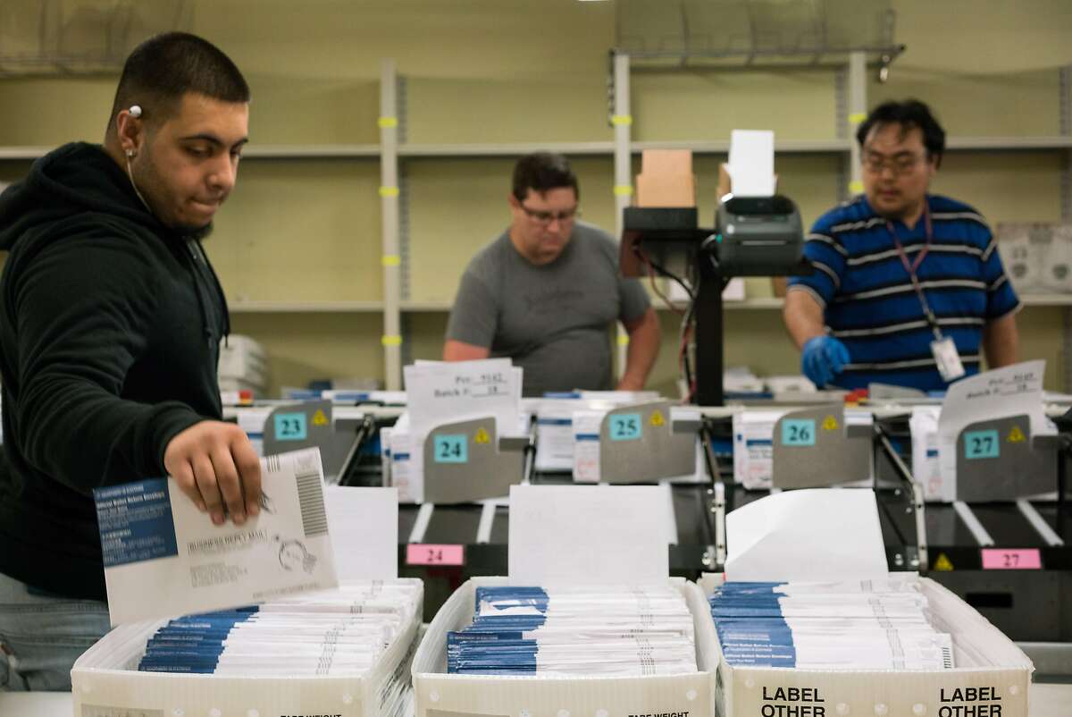 (Left to right) Damian Buoni, Zanzibar Tobogga and Joey Manalisay sort ballots at the City Hall Department of Elections in San Francisco, Calif. on Friday, June 8, 2018.