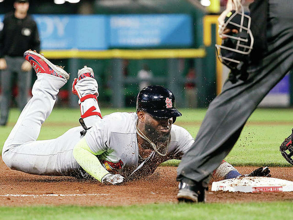 The Cardinals’ Marcell Ozuna slides into third on a triple off Cincinnati Reds relief pitcher Michael Lorenzen in the eighth inning of Friday night’s game in Cincinnati.
