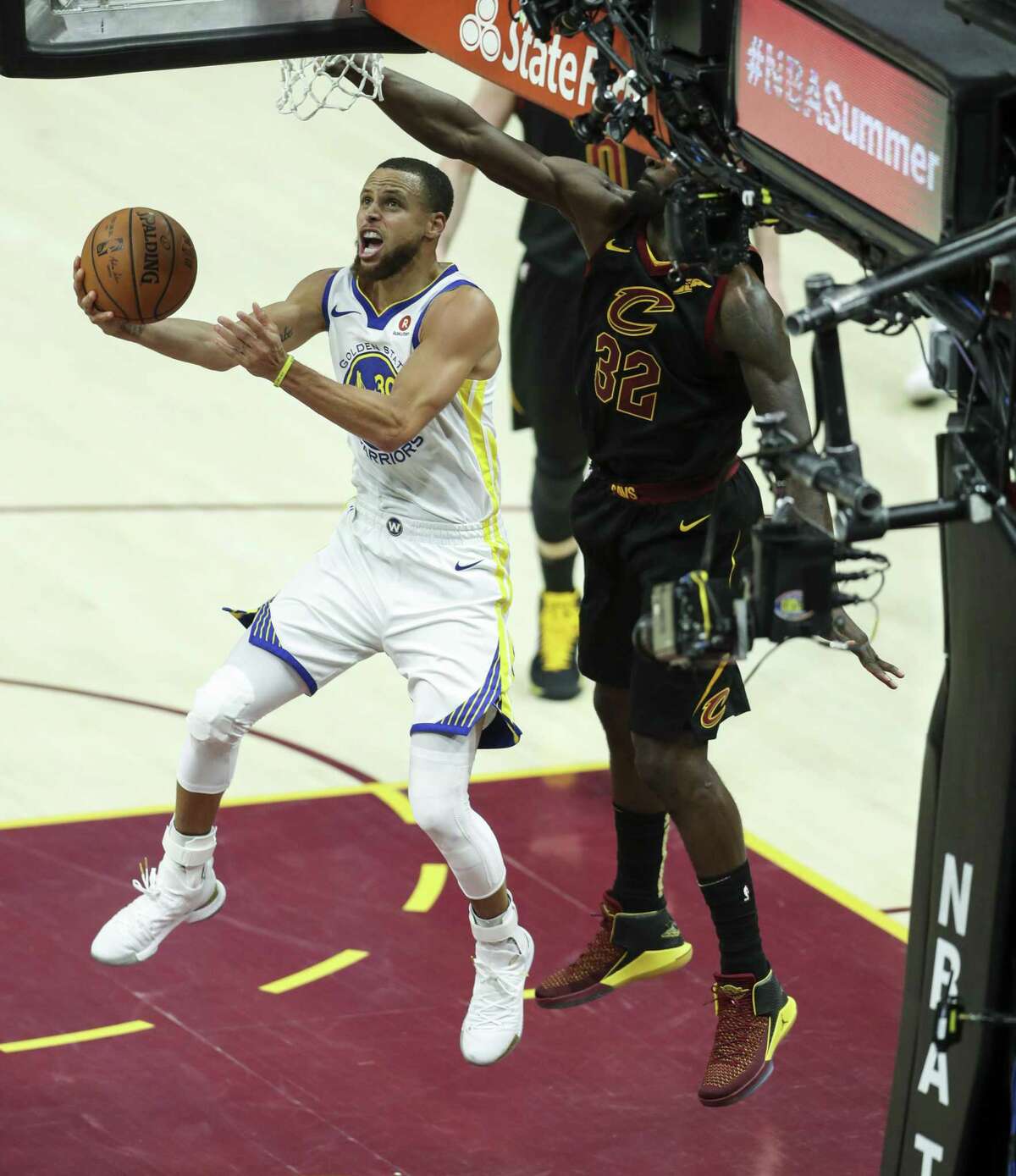 Golden State Warriors' Stephen Curry goes in for a layup under Cleveland Cavaliers' Jeff Green in the third quarter during game 4 of The NBA Finals between the Golden State Warriors and the Cleveland Cavaliers at Oracle Arena on Friday, June 8, 2018 in Cleveland, Ohio.
