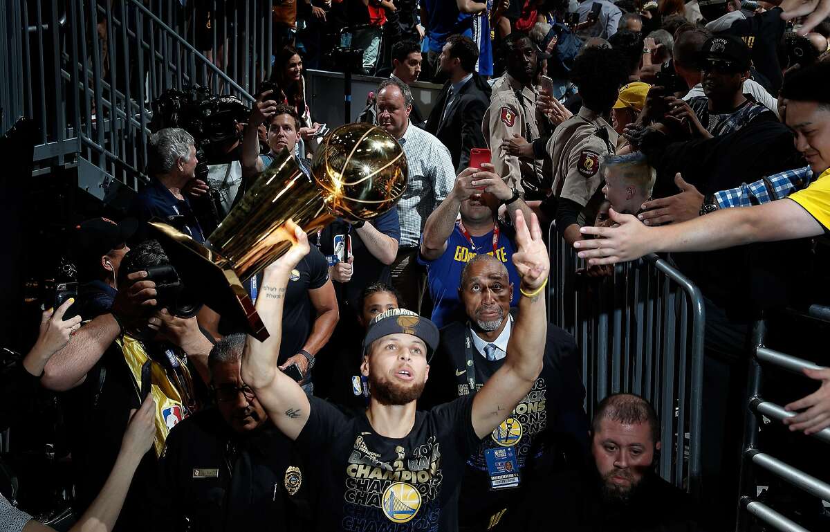 Stephen Curry (30) walks off the arena floor with the Larry O'Brien Trophy after the Golden State Warriors defeated the Cleveland Cavaliers in Game 4 of the NBA Finals at Quicken Loans Arena in Cleveland, Ohio, on Friday, June 8, 2018. The Warriors won 108-85 to win the the 2018 NBA Championship.