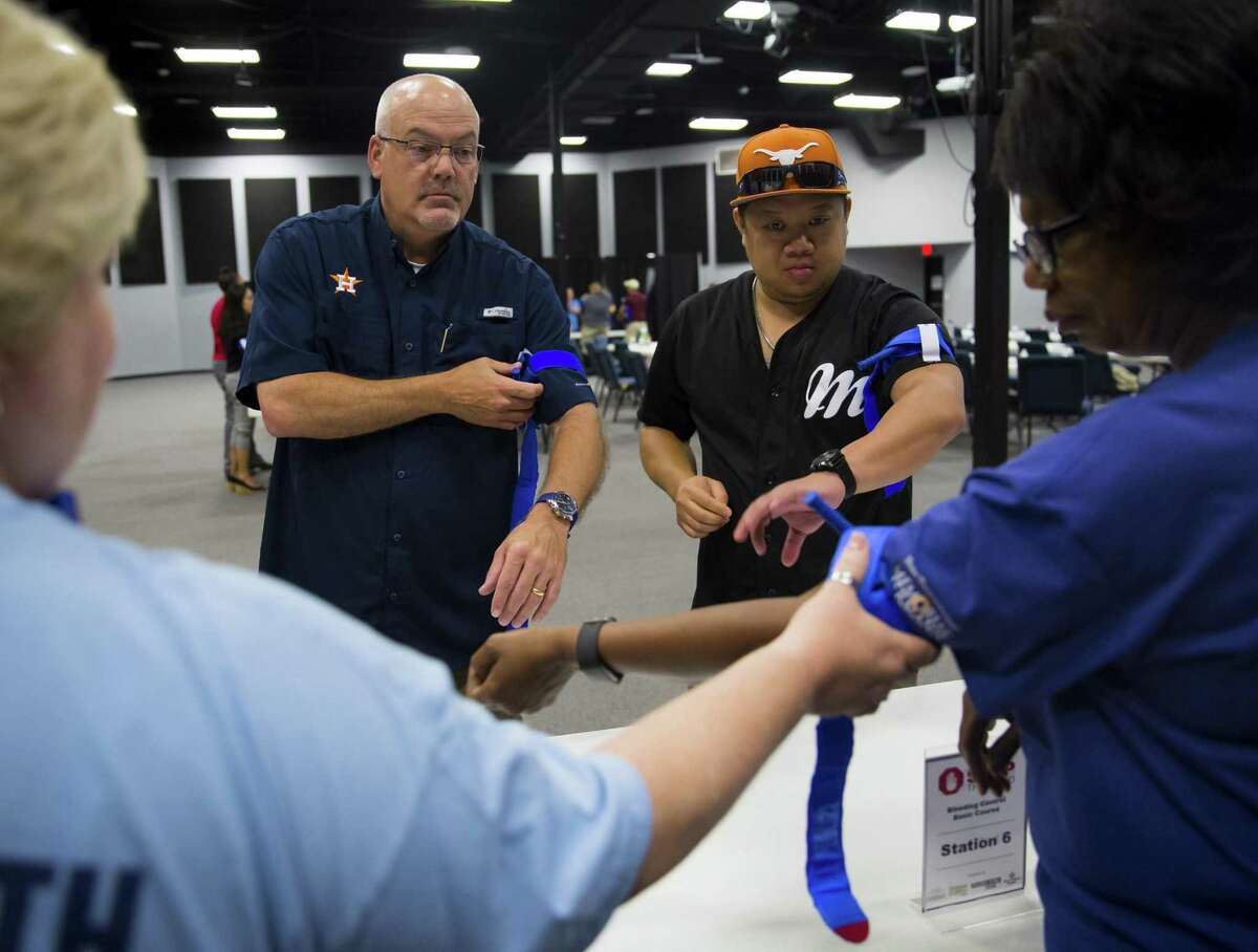 Bubba Wilson and Wilson Kwok practice using a tourniquet during Stop the Bleed, a free tourniquet/bleeding control training for the public in Sugar Land on Saturday, June 9, 2018. Participants received training on how to control life- and limb-threatening blood loss until a person can get treatment at a hospital. (Annie Mulligan / For the Houston Chronicle)