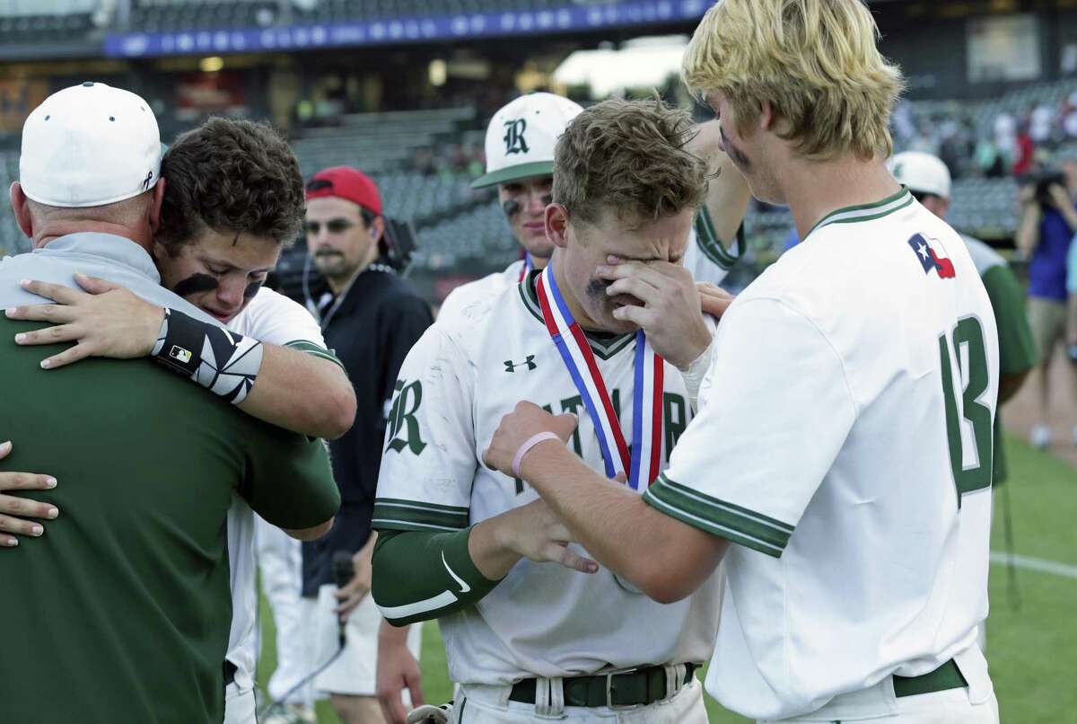Teammates console each other as Reagan loses 7-2 in the 6A state championship game to Southlake Carroll at Dell Diamond on June 9, 2018.