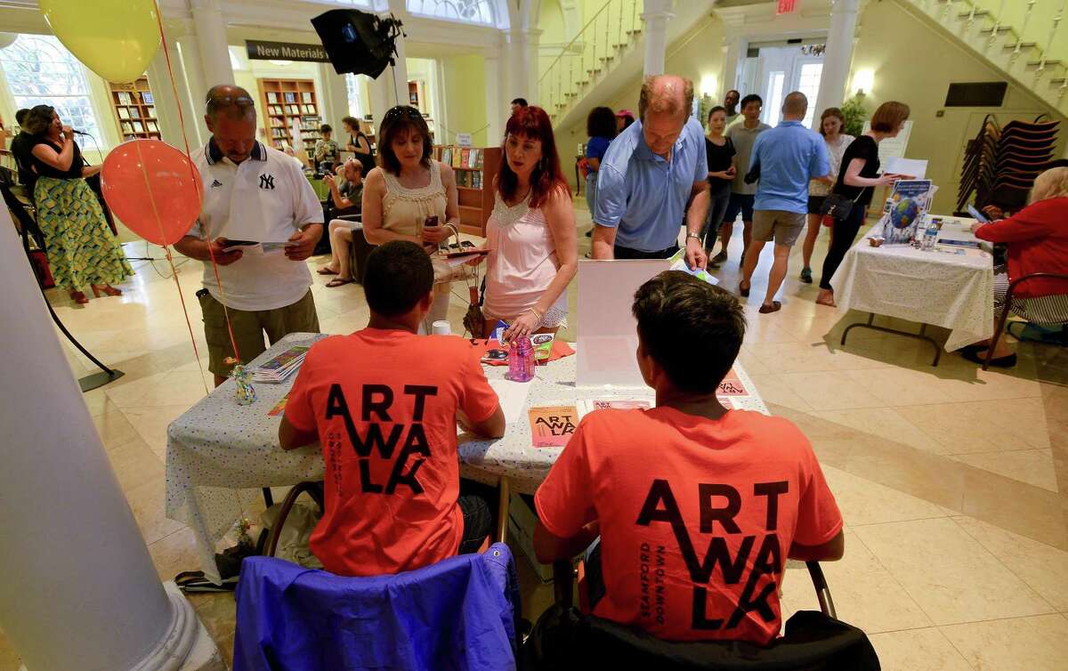 Art-lovers pick up information before beginning a tour of the 5th annual Artwalk in downtown Stamford last year. The event returns June 22.