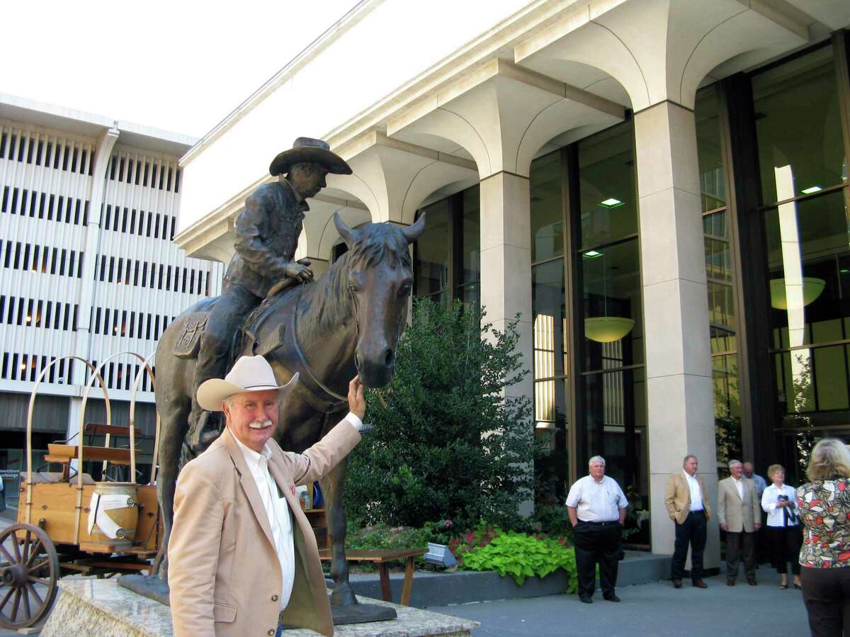 The late James F. Cotter set up chuck wagons and dressed in country western attire to celebrate the unveiling of a sculpture showing him riding his horse outside the 36-story Cotter Ranch Tower in Oklahoma City. The display includes hoof marks made in the cement plaza behind the sculpture.
