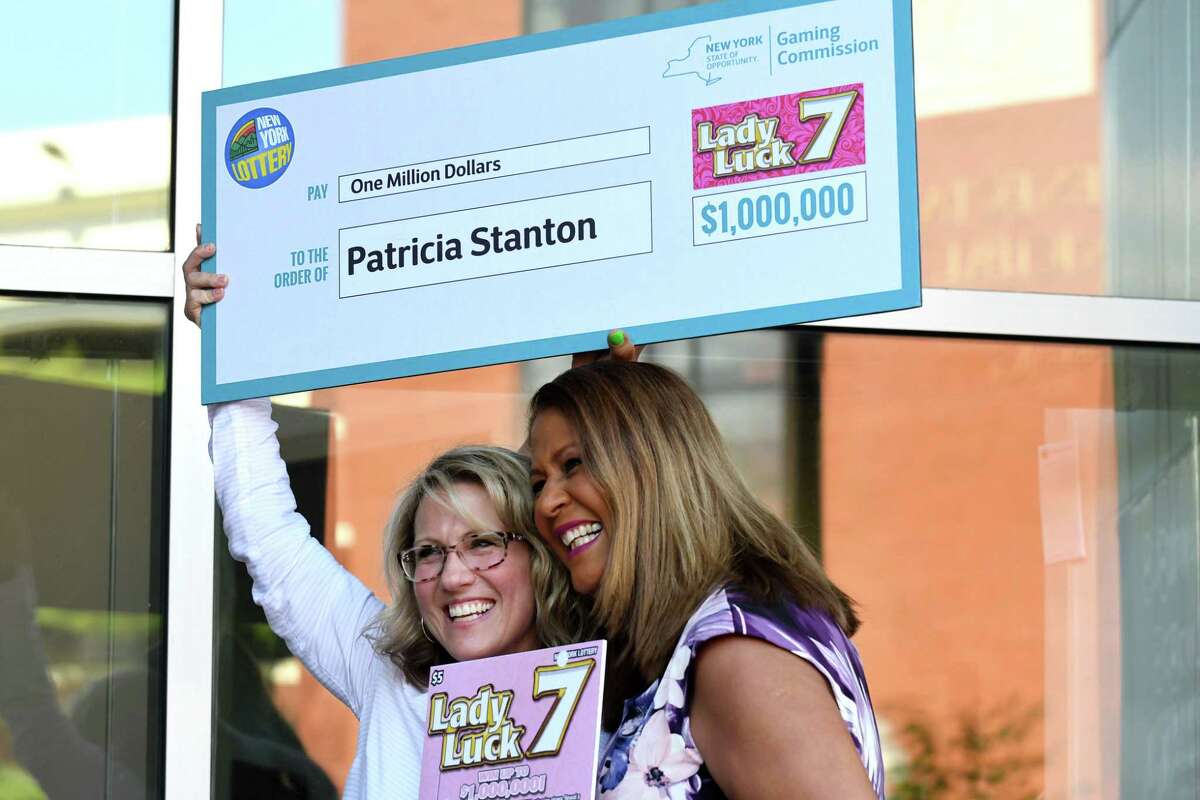 New York Lottery $1 million scratch-off ticket winner Patricia Stanton, left, is presented with a check by Yolanda Vega, right, during an announcement at the New York Lottery Headquarters on Tuesday, June 12, 2018, in Schenectady, N.Y. (Will Waldron/Times Union)
