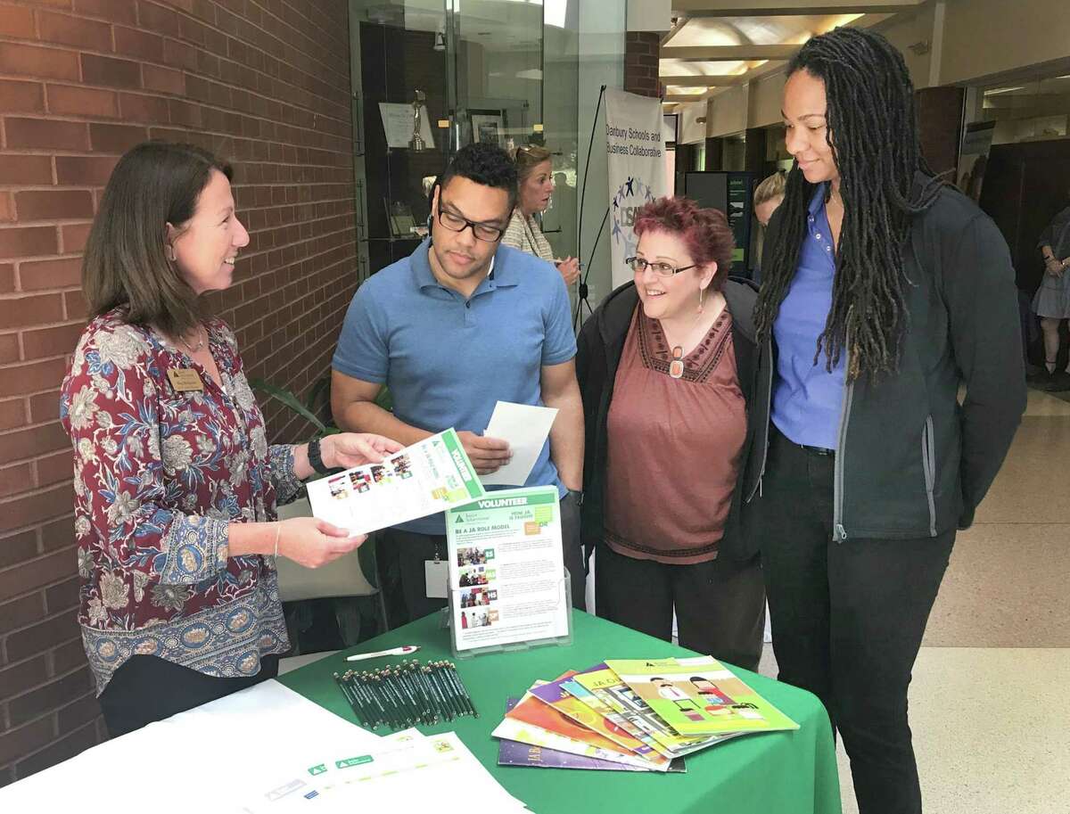 Meg Melagrano of Junior Achievement talks about her organization to Union Savings Bank employees Antony Velez, Tracy Gradia and Synnamon Smith during the bank's inaugural Community Fair held Tuesday, June 13, 2018, at the Galleria in downtown Danbury, Conn.