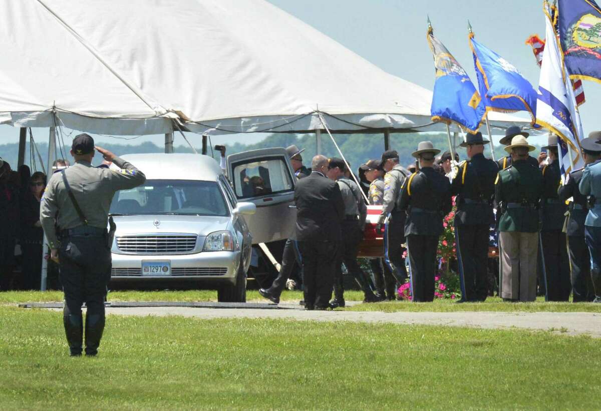 The casket containing Connecticut State Trooper 1st Class Walter Greene Jr. is moved into a hearse during a funeral service at Sherwood Island State Park Tuesday on in Westport.
