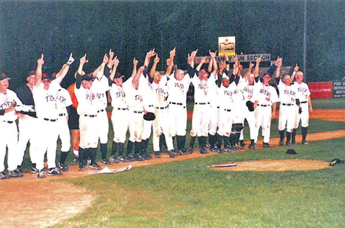 Members of the 1998 Edwardsville baseball team salute the crowd after winning the Class AA state championship.