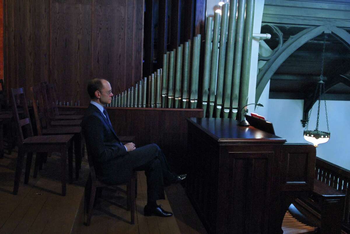 Actor David Hyde Pierce sits in the choir, left, before playing the second part of a duet with Bethesda Episcopal Church organist Farrell Goehring(playing on keyboard at center of altar in front of church, not shown ) on the George and Laura Pierce Memorial Organ, restored in the name of his late parents by their family, during a service at the church in Saratoga Springs, NY on Sunday October 11, 2009. He grew up attending the church, and practicing the organ as an assistant to the organist, as a teenager. FOR LAUREN STANFORTH STORY. (Philip Kamrass / Times Union)