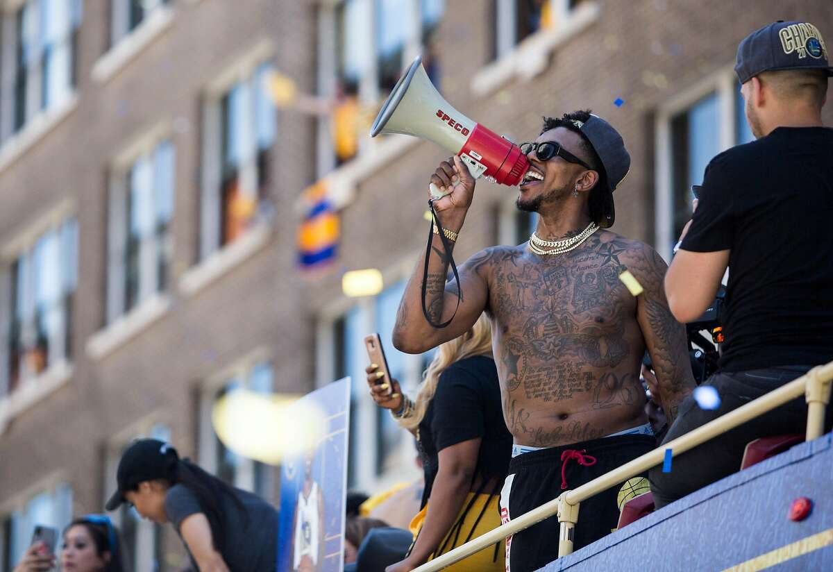 Warrios' Nick Young speaks into a megaphone while riding on a bus during the Golden State Warriors NBA Finals Championship parade in downtown Oakland, Calif. Tuesday, June 12, 2018.