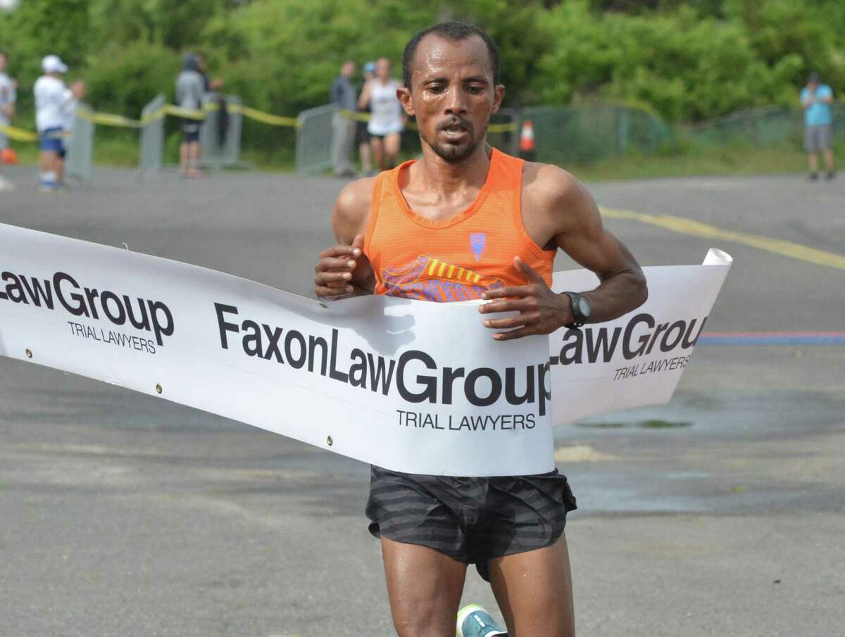 Kemal Birhann Dare of Ethiopia crosses the finish line in first place in the men’s division of the Faxon Law Group Fairfield half marathon on June 3.
