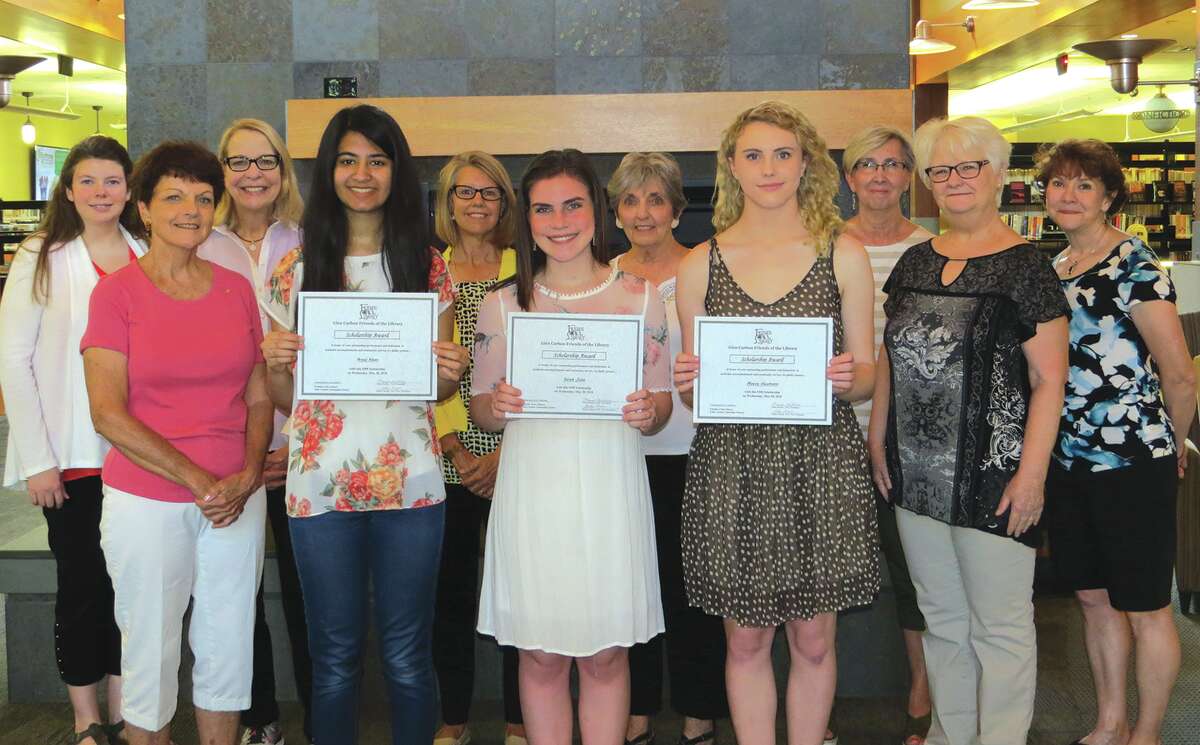 Areej Khan, Sarah Jobe, and Maeve Heumann hold their scholarship awards from the Friends of the Glen Carbon Library with members of the group.