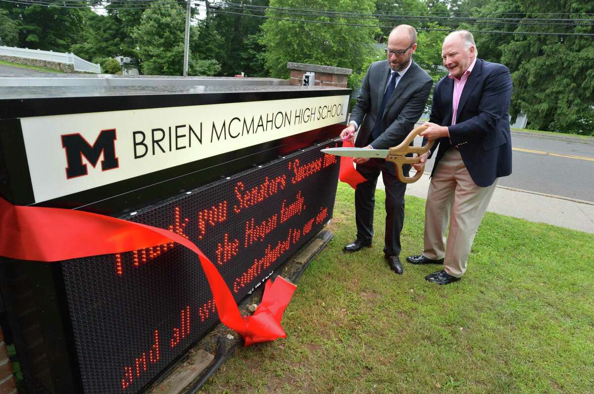 Brien McMahon High School Principal Scott Hurwitz and Jim Hogan cut the ribbon on the new electronic sign at the school during a dedication ceremony on Wednesday June 13, 2018 in Norwalk Conn. Jim's wife Leah Hogan who passed away this past fall was co-president of the parents group, Senators Success Fund that made the sign possible.