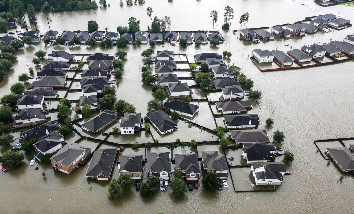 A neighborhood is inundated by floodwaters from Tropical Storm Harvey on Tuesday, Aug. 29, 2017, in Spring. Scientists say climate change will bring more powerful and destructive storm.