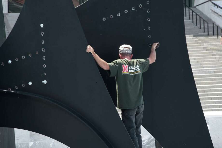 Workers dismantle and temporary remove artist Alexander CalderÕs abstract sculpture Triangles and Arches from the reflecting pool in front of the grand staircase on the south end of the Empire State Plaza on Thursday, June 14, 2018 in Albany, N.Y. (Lori Van Buren/Times Union) Photo: Lori Van Buren, Albany Times Union / 20043958A