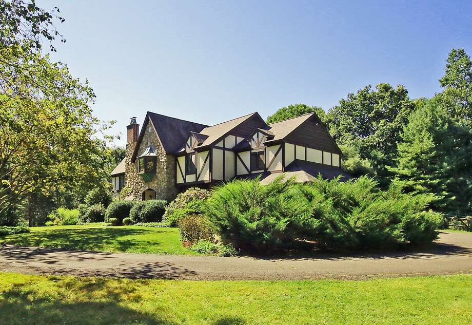 The English-Tudor style home at 15 Tunxis Trail in Redding was custom built in 1983 by an Italian stone mason. The house includes a library loft accessed by a spiral staircase, vast gardens and a "pub" with a bar imported from England by one of the previous homeowners, a British rocker. Photo: Contributed Photo / Contributed / The News-Times Contributed