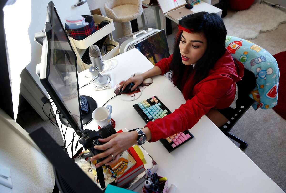 Shahmeen Kasim adjusts a camera before playing a game on Twitch at her home in San Francisco, Calif. on Wednesday, June 13, 2018. Kasim live streams herself painting watercolors and sculpting in addition to playing games on Twitch.