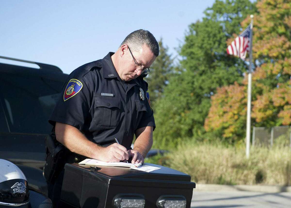 Stamford Police Officer Jeff Booth tickets drivers during a traffic stop for all violations, including blocking the box, at the intersection of Palmer Hill Road and Westover Road in Stamford, Conn., on October 3, 2014.