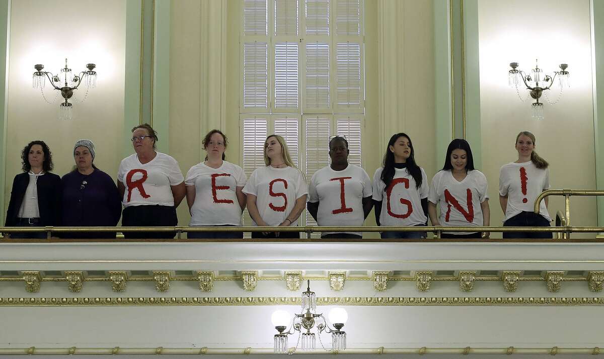 Protestors calling on Assemblywoman Cristina Garcia, D-Bell Gardens, to resign from office, stand in the Assembly gallery, Friday, May 25, 2018 in Sacramento, Calif. The protesters are part of an effort by labor organizations and building trade groups aiming to oust Garcia. Garcia took a three-month leave of absence after a groping allegation and other claims of inappropriate behavior surfaced. Outside investigators cleared her of the groping claim but found she used vulgar language in violation of the Assembly's sexual harassment policy. (AP Photo/Rich Pedroncelli)
