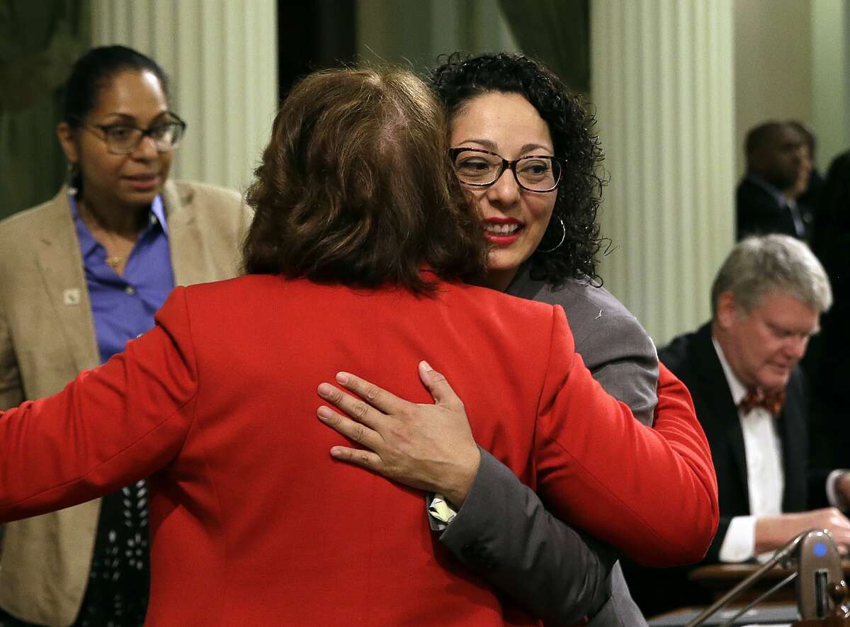 Assemblywoman Cristina Garcia, D-Bell Gardens, right, is hugged by Assemblywoman Eloise Gomez Reyes, D-Grand Terrace, on her first day back in the Assembly since an investigation into sexual misconduct charges, Friday, May 25, 2018, Sacramento, Calif. Garcia took a three-month leave of absence after a groping allegation and other claims of inappropriate behavior surfaced. Outside investigators cleared her of the groping claim but found she used vulgar language in violation of the Assembly's sexual harassment policy. (AP Photo/Rich Pedroncelli)