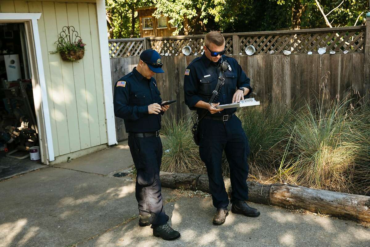 Marin County firefighters, Cole Rippe and Alex Mercer go through a check list of recommendations for a property during a defensible space inspection in Woodacre, Calif., Wednesday, June 6, 2018.