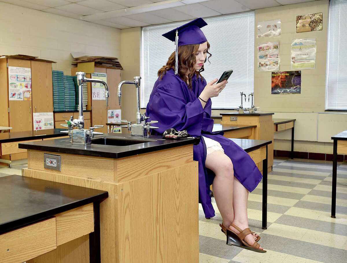 Alannah Miessau texts her boyfriend Alex from a chemistry lab before commencement exercises begin at North Branford High School, Friday, June 15, 2018.