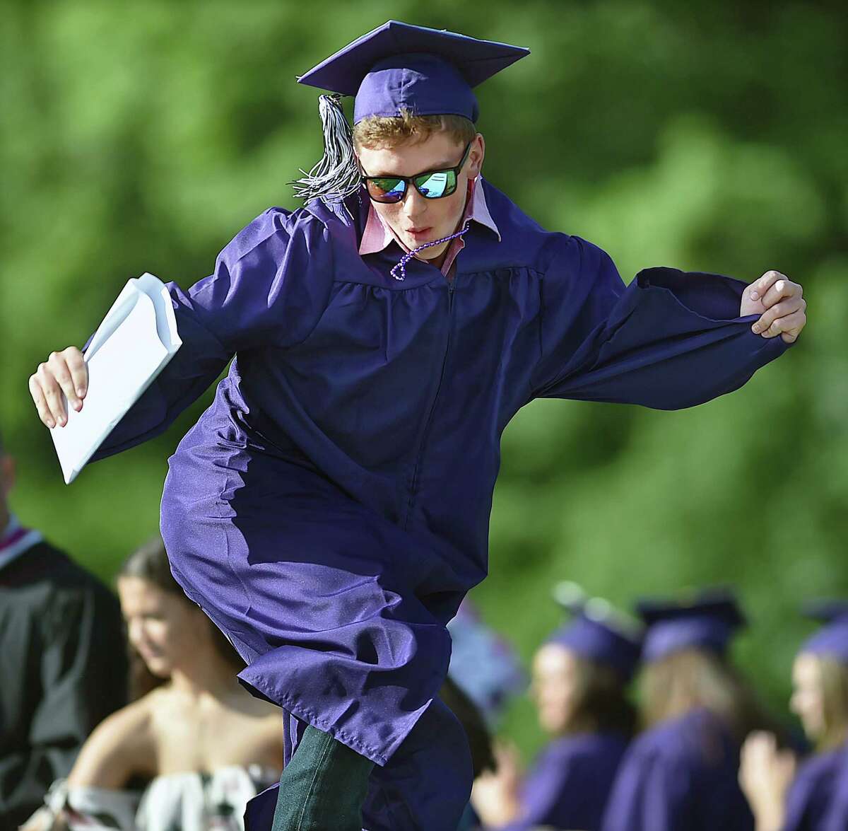 Riley Anderson celebrates after receiving his diploma at commencement exercises at North Branford High School at George A. Colafati Field, Friday, June 15, 2018.
